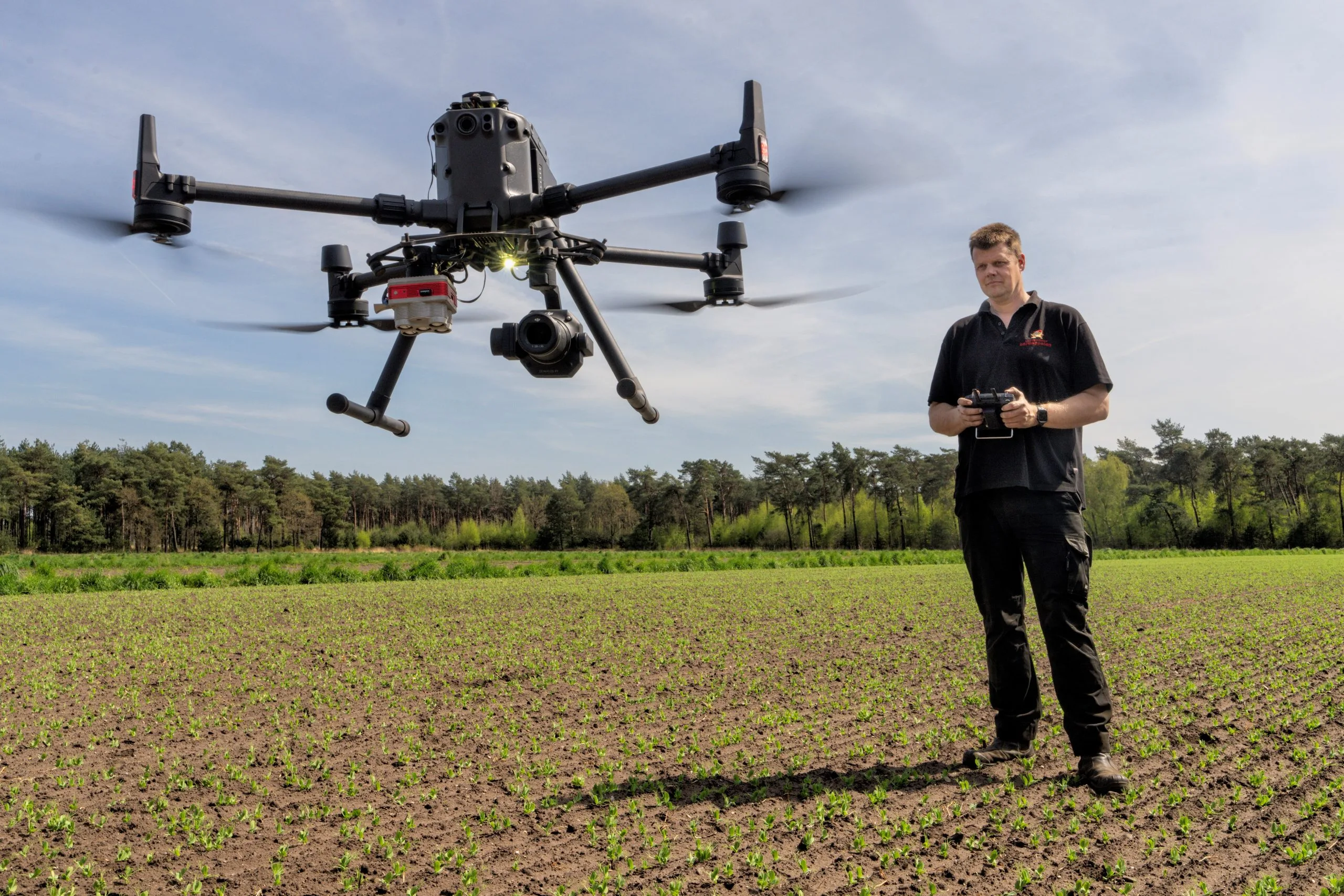 Engineer operating an agricultural drone over a crop field in the Netherlands